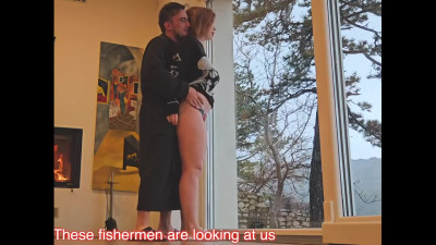 Busty redhead is getting her pussy fucked in front of the window
