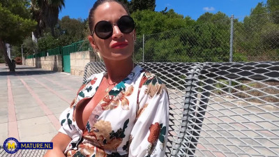 Skinny MILF Leidy De Leon is giving a nice blowjob to a bald guy in the forest